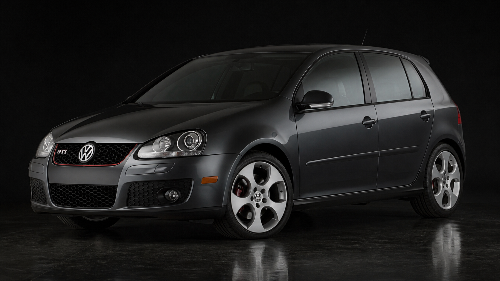 Realistic dark graphite 2008 Volkswagen Golf GTI Mk5 in a studio, showing the Mk5 headlights, honeycomb grille, red grille stripe, hatchback profile, and period-correct wheels